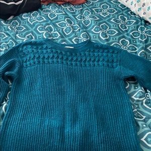 A sparkly teal sweater and a white sparkly sweater